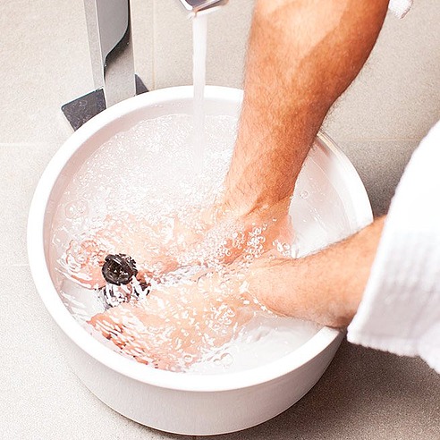 Männliche Person nimmt Fußbad | Tiger Balm