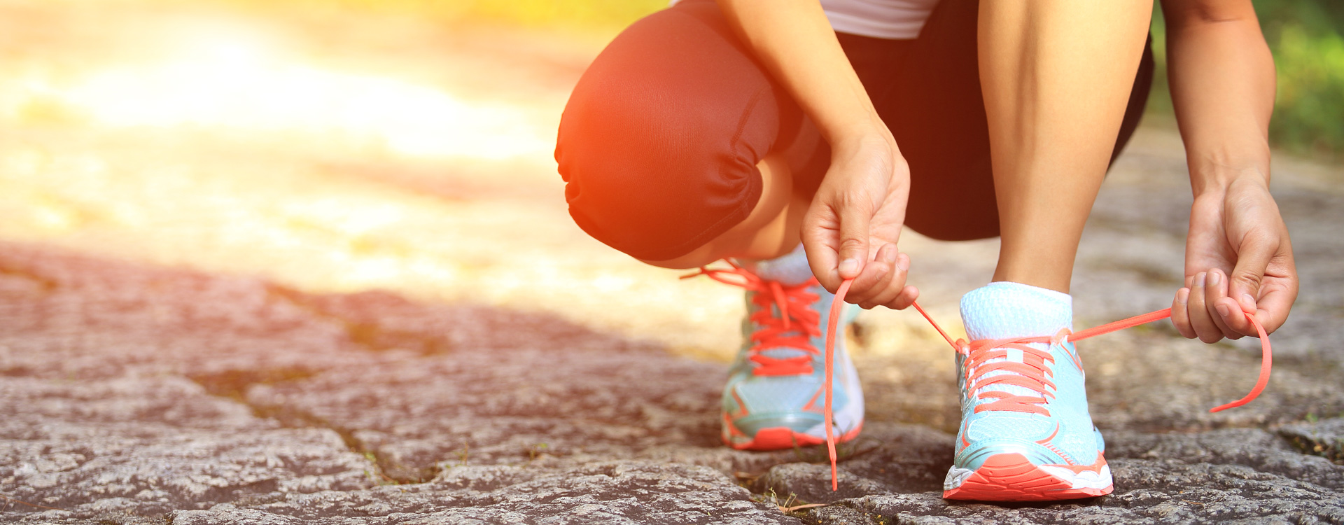 Weibliche Person schnürt Laufschuhe | Tigerbalm
